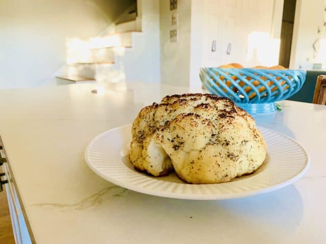 Learn how to make a delicious whole roasted cauliflower recipe that kids, and even picky eaters, will love. It's unique, easy, and only has a few simple ingredients!